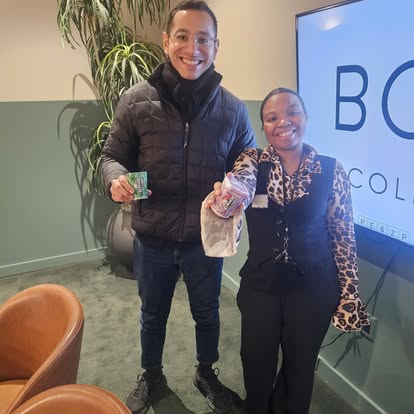 Two club members smiling together and holding small items