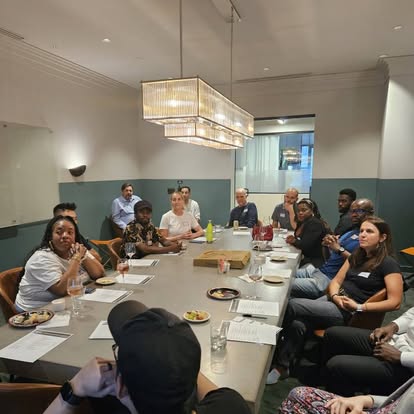 Club members seated around a conference table at an in-person gathering